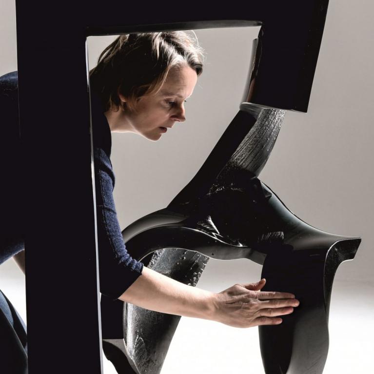 Anda Munkevica with her work Virility from the series Black Horses. 2018. Glass, fused, hot sculpted, polished. Photo: Ilmārs Znotiņ&scaron;