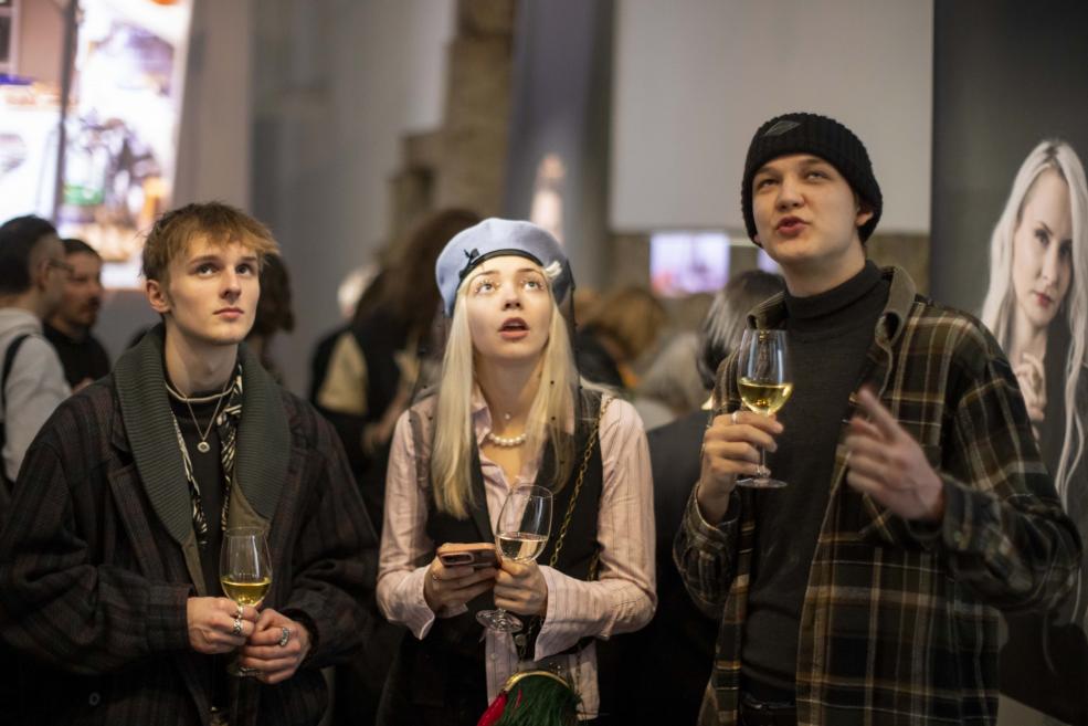 Visitors to the jewelry exhibition with wine glasses in their hands