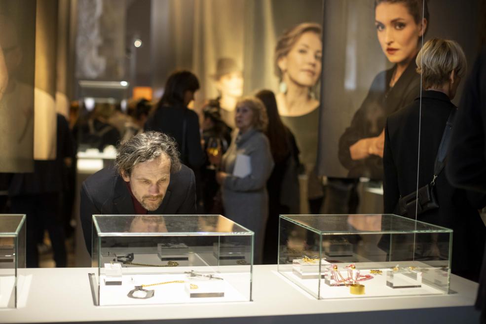 The visitor examines the jewelry in the showcase