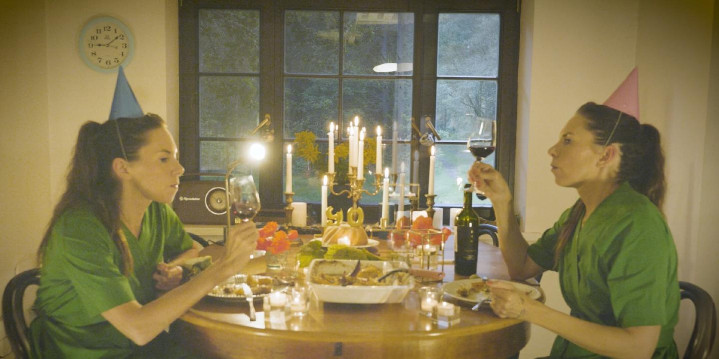 Sieviete un dubultniece sēž pie galda