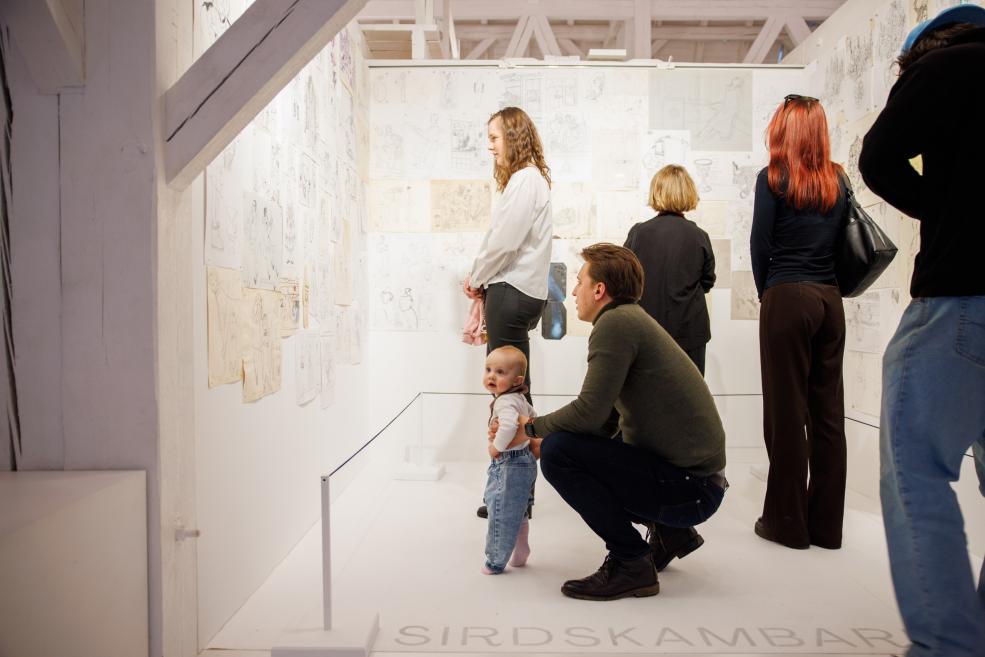 Exhibition visitors view the works